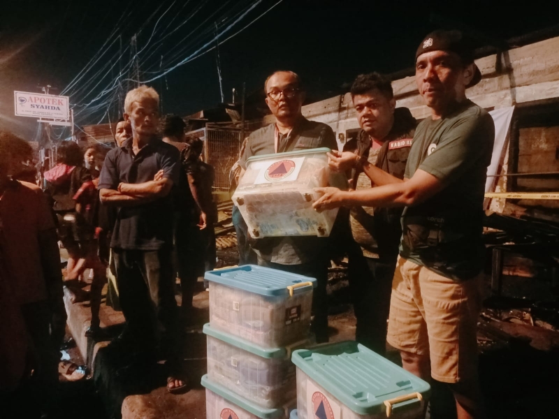 BPBD Padang menyalurkan bantuan kepada pemilik toko yang terdampak kebakaran di kawasan pertokoan Parupuk Tabing, Jumat malam (30/5/2025). (Foto: BPBD Padang)