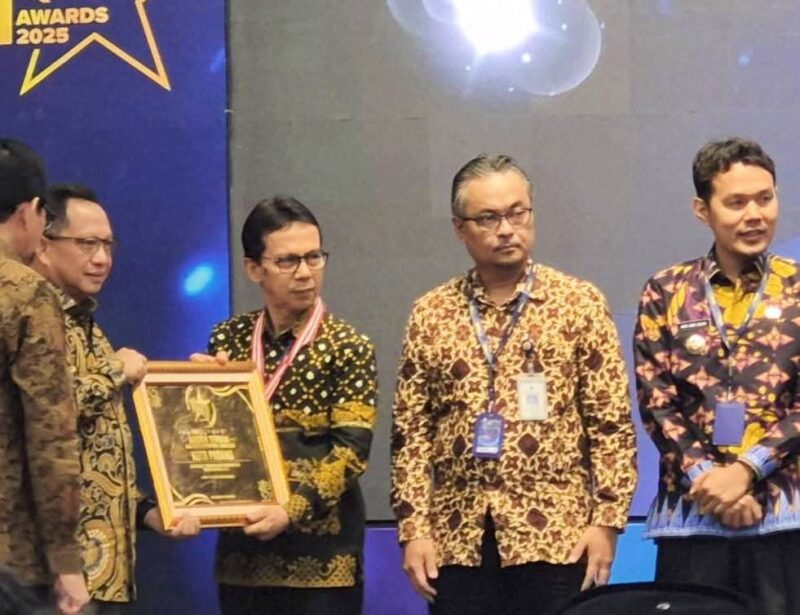 Asisten I Setdako Padang Edi Hasymi menerima SPM Awards 2025 dari Mendagri Tito Karnavian, Jumat (23/5/2025). (Foto: Diskominfo Padang)