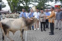 Wakil Wali Kota Padang, Maigus Nasir menyerahkan secara simbolis hewan kurban kepada perwakilan pengurus rumah ibadah di halaman kantor Perumda AM Kota Padang, Rabu (14/5/2025). (Foto: Prokopim Padang)