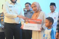 Wali Kota Padang Fadly Amran menyerahkan secara simbolis kartu Padang Juara kepada perwakilan orang tua siswa. (Foto: Prokopim Padang)