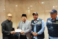 Chief Operating Officer BPKH Limited, Iman Ni’matullah menyalurkan dana kompensasi kepada jemaah yang tidak mendapat makanan. (Foto: Ist)