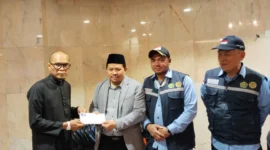 Chief Operating Officer BPKH Limited, Iman Ni’matullah menyalurkan dana kompensasi kepada jemaah yang tidak mendapat makanan. (Foto: Ist)