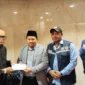 Chief Operating Officer BPKH Limited, Iman Ni’matullah menyalurkan dana kompensasi kepada jemaah yang tidak mendapat makanan. (Foto: Ist)