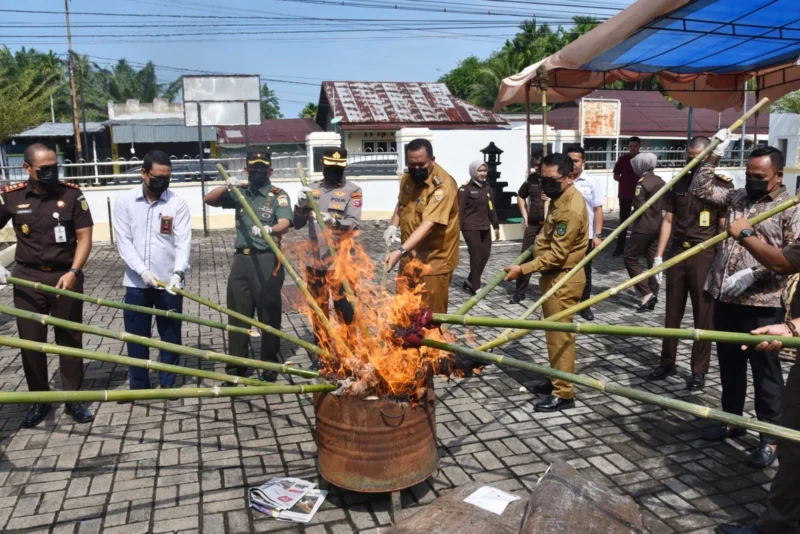 Wali Kota Pariaman, Yota Balad ikut melakukan pemusnahan barang bukti yang telah berkekuatan hukum tetap di Halaman Kejaksaan Negeri Pariaman, Senin (16/6). (Foto: Kominfo Pariaman)
