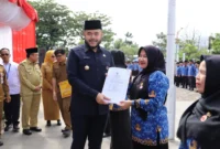 Wali Kota Padang Fadly Amran menyerahkan secara simbolis SK Pengangkatan PPPK formasi 2024 kepada salah seorang PPPK di Lapangan Apeksi, Balai Kota Aia Pacah, Senin (30/6/2025). (Foto: Prokopim Padang)