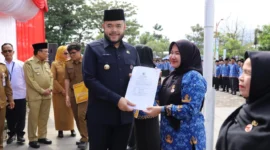 Wali Kota Padang Fadly Amran menyerahkan secara simbolis SK Pengangkatan PPPK formasi 2024 kepada salah seorang PPPK di Lapangan Apeksi, Balai Kota Aia Pacah, Senin (30/6/2025). (Foto: Prokopim Padang)