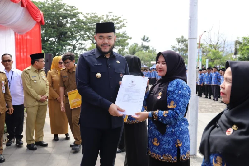 Wali Kota Padang Fadly Amran menyerahkan secara simbolis SK Pengangkatan PPPK formasi 2024 kepada salah seorang PPPK di Lapangan Apeksi, Balai Kota Aia Pacah, Senin (30/6/2025). (Foto: Prokopim Padang)