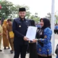 Wali Kota Padang Fadly Amran menyerahkan secara simbolis SK Pengangkatan PPPK formasi 2024 kepada salah seorang PPPK di Lapangan Apeksi, Balai Kota Aia Pacah, Senin (30/6/2025). (Foto: Prokopim Padang)
