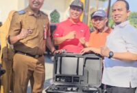 Ketua DPRD Padang Muharlion menyerahkan alat rekam data adminduk kepada Camat Koto Tangah Fizlan Setiawan, Selasa (3/6/2025). (Foto: Diskominfo Padang)
