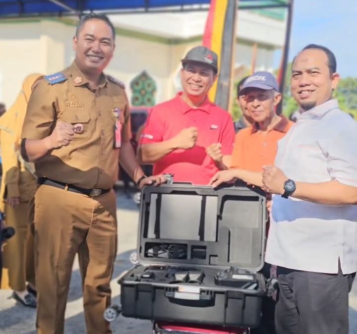 Ketua DPRD Padang Muharlion menyerahkan alat rekam data adminduk kepada Camat Koto Tangah Fizlan Setiawan, Selasa (3/6/2025). (Foto: Diskominfo Padang)