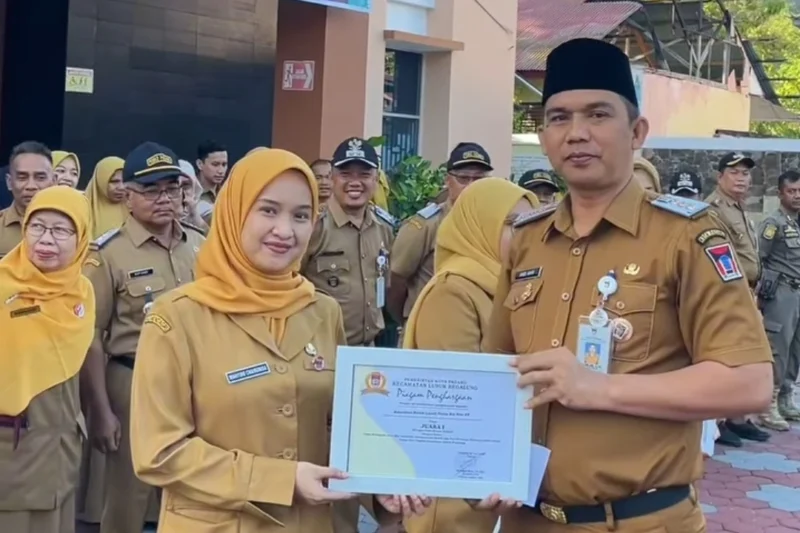 Camat Lubeg Nofiandi Amir menyerahkan piagam penghargaan kepada ASN atas kontribusi mereka dalam pembuatan video kreatif memperingati HANI dan Harganas. (Foto: Ist)
