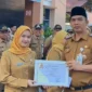 Camat Lubeg Nofiandi Amir menyerahkan piagam penghargaan kepada ASN atas kontribusi mereka dalam pembuatan video kreatif memperingati HANI dan Harganas. (Foto: Ist)