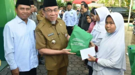 Wakil Wali Kota Padang Maigus Nasir didampingi Kakan Kemenag Edy Oktafiandi menyerahkan bantuan kepada penerima manfaat pada Festival Muharram 1447 H, Selasa (8/7/2025). (Foto: Prokopim Padang)