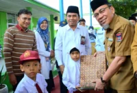 Wakil Wali Kota Padang Maigus Nasir menyerahkan bantuan seragam gratis kepada siswa madrasah di MTsN 6 Kota Padang, Selasa (22/7/2025). (Foto: Prokopim Padang)