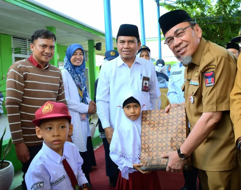 Wakil Wali Kota Padang Maigus Nasir menyerahkan bantuan seragam gratis kepada siswa madrasah di MTsN 6 Kota Padang, Selasa (22/7/2025). (Foto: Prokopim Padang)