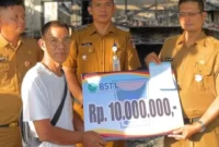 Camat Lubeg Nofiandi Amir menyerahkan bantuan Pemko Padang kepada korban kebakaran di Gates Nan XX, Senin (30/6/2025). (Foto: Ist)