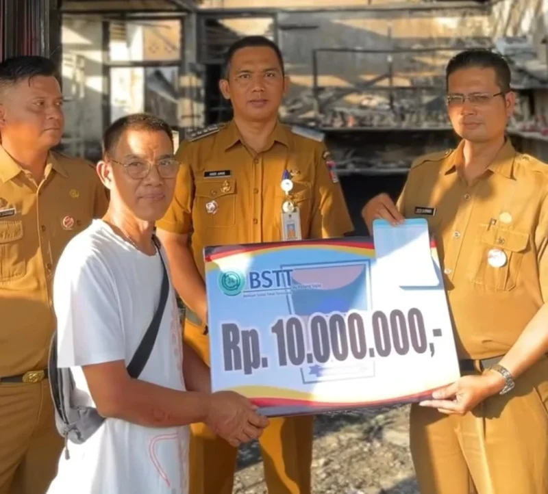 Camat Lubeg Nofiandi Amir menyerahkan bantuan Pemko Padang kepada korban kebakaran di Gates Nan XX, Senin (30/6/2025). (Foto: Ist)