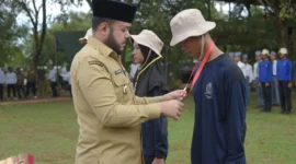 Wali Kota Padang Fadly mengalungkan tanda peserta DIKSISTA MAN 3 Padang di Bumi Perkemahan Sungrilla, Kecamatan Koto Tangah, Senin (21/7/2025). (Foto: Prokopim Padang)