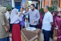 Wali Kota Padang Fadly Amran menyerahkan baju seragam sekolah gratis kepada peserta didik baru di SMPN 2 Padang, Jumat (11/7/2025). (Foto: Eko Syaf)
