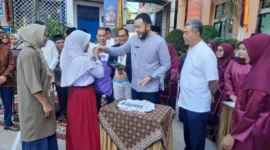 Wali Kota Padang Fadly Amran menyerahkan baju seragam sekolah gratis kepada peserta didik baru di SMPN 2 Padang, Jumat (11/7/2025). (Foto: Eko Syaf)