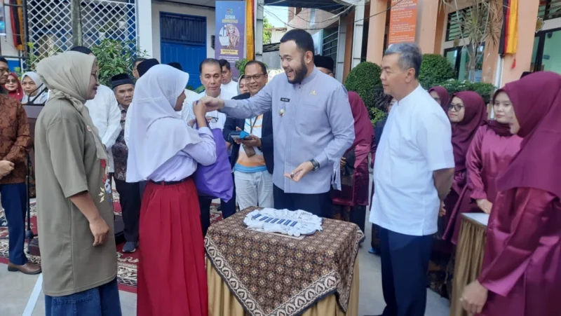 Wali Kota Padang Fadly Amran menyerahkan baju seragam sekolah gratis kepada peserta didik baru di SMPN 2 Padang, Jumat (11/7/2025). (Foto: Eko Syaf)