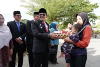 Bupati Eka Putra menyerahkan bantuan kepada anak balita yang terdampak stunting. (Foto: Prokopim Tanah Datar)