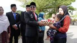 Bupati Eka Putra menyerahkan bantuan kepada anak balita yang terdampak stunting. (Foto: Prokopim Tanah Datar)