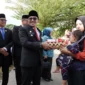 Bupati Eka Putra menyerahkan bantuan kepada anak balita yang terdampak stunting. (Foto: Prokopim Tanah Datar)