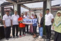 Camat Nanggalo, Amrizal Rengganis menyerahkan bantuan secara simbolis kepada korban kebakaran, Rabu (2/7/2025). (Foto: Diskominfo Padang)