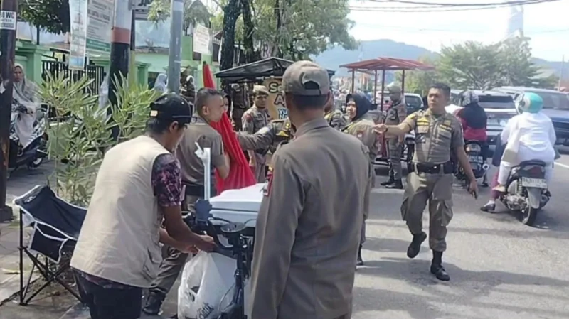 Petugas Satpol PP Padang menertibkan PKL yang menggunakan badan jalan dan trotoar sebagai lokasi berjualan di kawasan Padang Timur, Senin (7/7/2025). (Foto: Humas Satpol PP Padang)