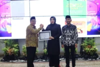 Wali Kota Padang Panjang, Hendri Arnis didampingi Wakil Wali Kota Allex menyerahkan penghargaan kepada Kajari sebelumnya, Jerniaty, SH, MH. (Foto: Kominfo Padang Panjang)