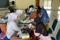 Proses distribusi lembaran belanja bagi siswa penerima bantuan perlengkapan sekolah gratis di Kantor Disdikbud, Jumat (11/7/2025). (Foto: Kominfo Padang Panjang)