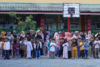Para orang tua bersama anak-anaknya saat penyerahan seragam sekolah gratis di SDN 03 Alai, Kecamatan Padang Utara, Jumat (11/7/2025). (Foto: Diskominfo Padang)