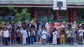 Para orang tua bersama anak-anaknya saat penyerahan seragam sekolah gratis di SDN 03 Alai, Kecamatan Padang Utara, Jumat (11/7/2025). (Foto: Diskominfo Padang)