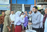 Wali Kota Padang Fadly Amran menyerahkan secara simbolis baju seragam sekolah gratis kepada peserta didik baru di SMPN 2 Padang, Jumat (11/7/2025). (Foto: Prokopim Padang)