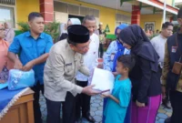 Wakil Wali Kota Padang, Maigus Nasir menyerahkan seragam sekolah gratis kepada peserta didik di SDN 03 Alai, Kecamatan Padang Utara, Jumat (11/7/2025). (Foto: Diskominfo Padang)