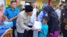 Wakil Wali Kota Padang, Maigus Nasir menyerahkan seragam sekolah gratis kepada peserta didik di SDN 03 Alai, Kecamatan Padang Utara, Jumat (11/7/2025). (Foto: Diskominfo Padang)