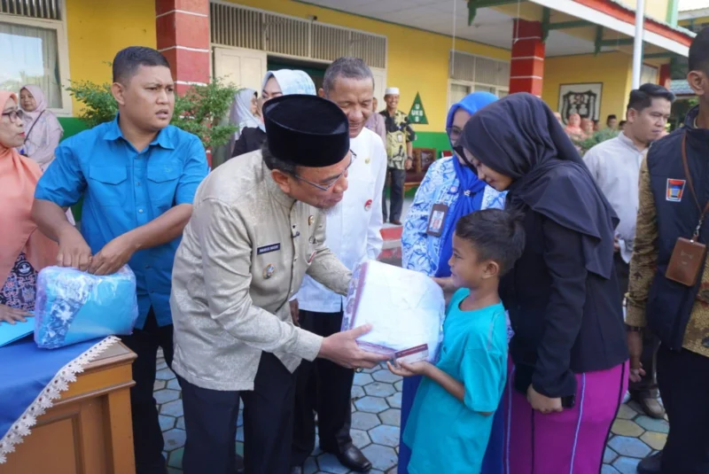 Wakil Wali Kota Padang, Maigus Nasir menyerahkan seragam sekolah gratis kepada peserta didik di SDN 03 Alai, Kecamatan Padang Utara, Jumat (11/7/2025). (Foto: Diskominfo Padang)