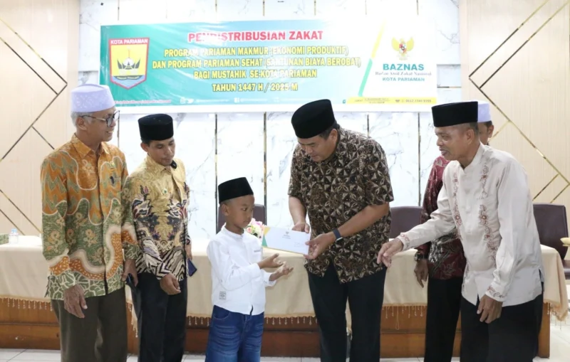 Wali Kota Pariaman, Yota Balad menyerahkan zakat kepada mustahik di Balairung Rumah Dinas Wali Kota, Jumat (18/7/2025). (Foto: Kominfo Pariaman)