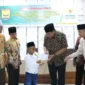 Wali Kota Pariaman, Yota Balad menyerahkan zakat kepada mustahik di Balairung Rumah Dinas Wali Kota, Jumat (18/7/2025). (Foto: Kominfo Pariaman)