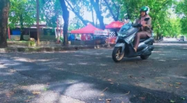 Seorang pengendara sepeda motor tengah melintas di jalan yang sudah ditambal oleh Pemko Padang. (Foto: FB Diskominfo Padang)