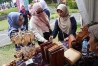 Ketua Dekranasda Padang Panjang, Ny. Maria Feronika Hendri meninjau stand dalam Festival Literasi di PDIKM, Minggu (27/7/2025). (Foto: Kominfo Padang Panjang)