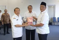 Wakil Bupati Pasaman Barat, M. Ihpan menerima buku sejarah dan budaya dari Kepala Dinas Kebudayaan Sumbar Dr. H. Jefrinal Arifin, Rabu (30/7/2025). (Foto: Diskominfo Pasbar)