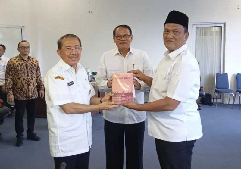 Wakil Bupati Pasaman Barat, M. Ihpan menerima buku sejarah dan budaya dari Kepala Dinas Kebudayaan Sumbar Dr. H. Jefrinal Arifin, Rabu (30/7/2025). (Foto: Diskominfo Pasbar)