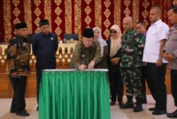 Wali Kota Payakumbuh Zulmaeta menandatangani dokumen pengesahan dua Perda usai rapat paripurna DPRD, Jumat (4/7/2025). (Foto: Pemko Payakumbuh)