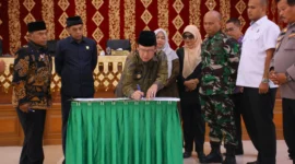 Wali Kota Payakumbuh Zulmaeta menandatangani dokumen pengesahan dua Perda usai rapat paripurna DPRD, Jumat (4/7/2025). (Foto: Pemko Payakumbuh)