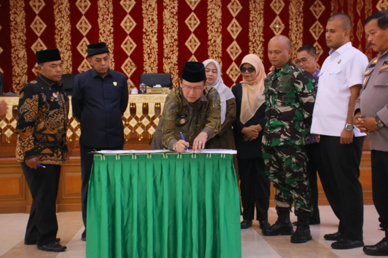 Wali Kota Payakumbuh Zulmaeta menandatangani dokumen pengesahan dua Perda usai rapat paripurna DPRD, Jumat (4/7/2025). (Foto: Pemko Payakumbuh)