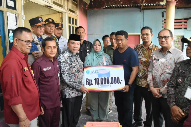 Wakil Wali Kota Padang, Maigus Nasir menyerahkan bantuan kepada korban kebakaran di Jalan Makasar No.35 RT 03 RW 03, Kelurahan Gates Nan XX, Kecamatan Lubuk Begalung, Kamis (10/7/2025). (Foto: Prokopim Padang)