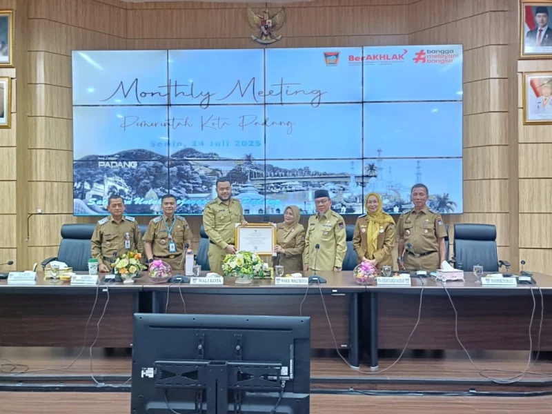 Kepala Dispusip Padang Feri Mulyani menyerahkan penghargaan Simpul Jaringan Kearsipan Terbaik 2025 dari ANRI kepada Wali Kota Padang Fadly Amran di sela-sela monthly meeting, Senin (14/7/2025). (Foto: Prokopim Padang)