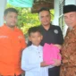 Wawako Padang, Maigus Nasir menyerahkan paket bingkisan pendidikan dari Yayasan Sosial Lebah Muda kepada peserta didik kurang mampu di Kota Padang, Minggu (13/7/2025). (Foto: Prokopim Padang)